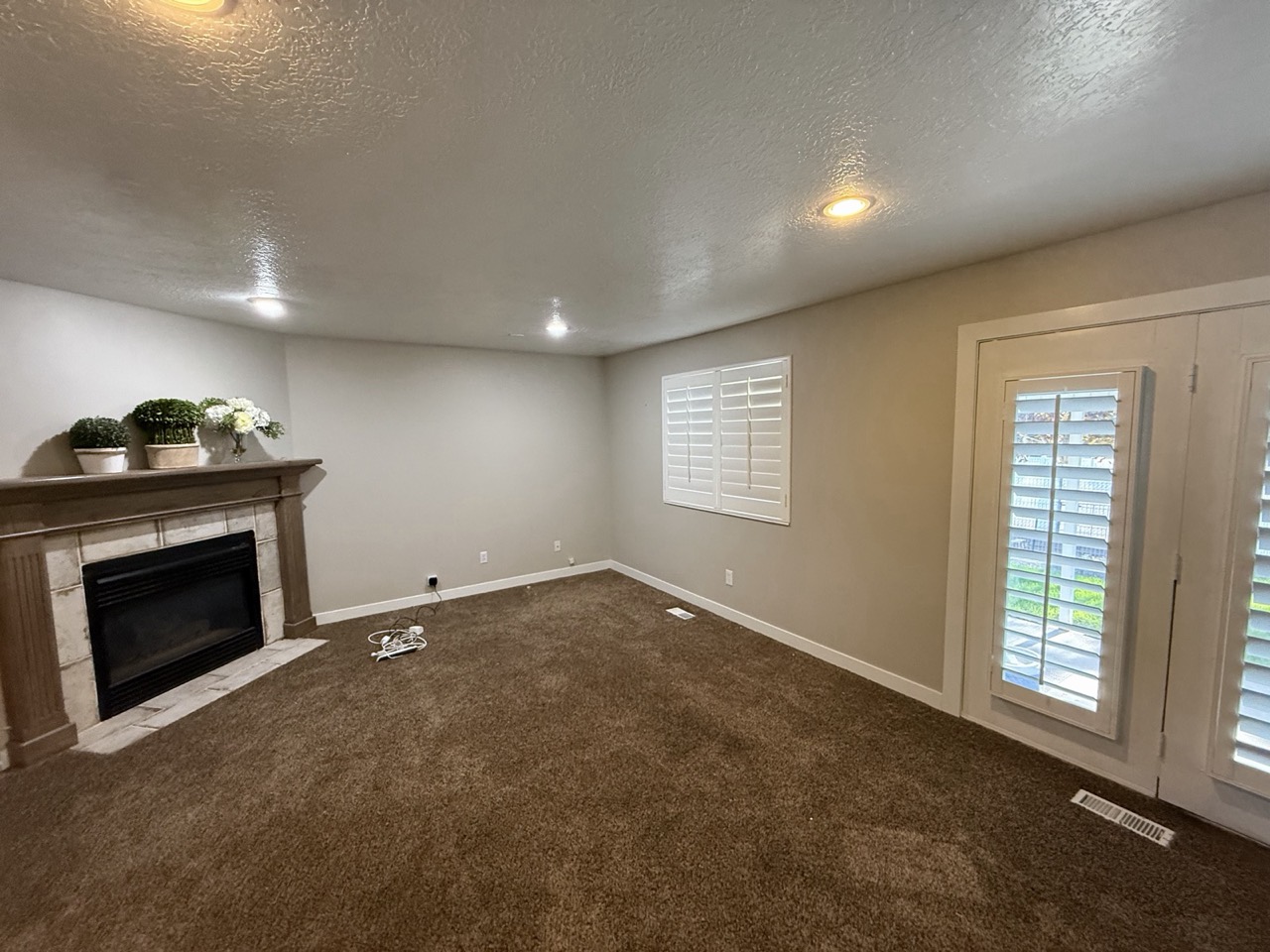 Living room with freshly painted walls, fireplace and white shutters